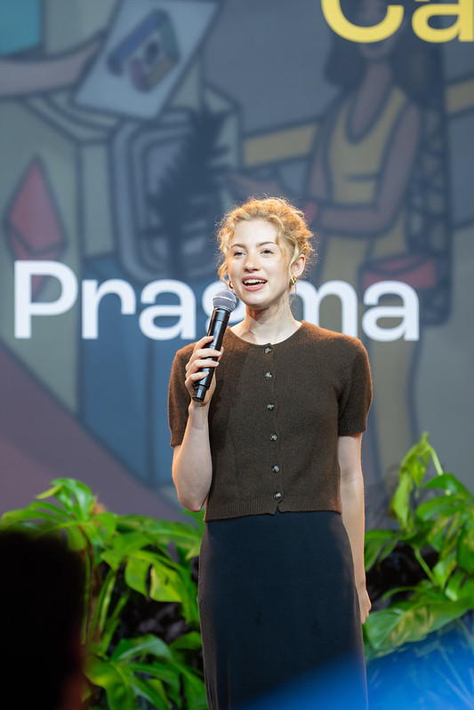 A woman speaking into a microphone on the Pragma stage